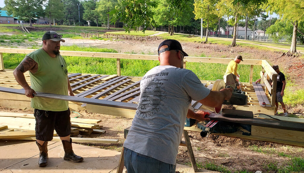 Local volunteers from the International Union of Elevator Constructors rebuild a fishing pier at the Texas Freshwater Fisheries Center.